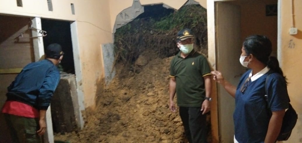 Camat Bengkayang, Dominus Robinson (bertopi) meninjau rumah warga yang terkena longsor. Foto: Kurnadi/Jurnalis.co.id