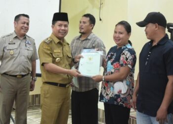 Bupati Sambas menyerahkan sertifikat kepada warga Kecamatan Subah. Foto: Imbran/Jurnalis.co.id