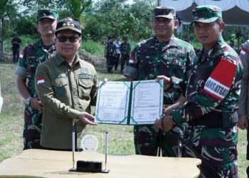 Haji Satono menyerahkan Berita Acara proyek TMMD ke 119, dari Pemkab Sambas ke Dandim 1208/Sambas. Foto: Imbran/Jurnalis.co.id