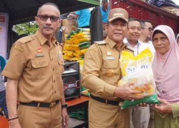 Pj Bupati Sanggau Suherman menyalurkan paket sembako murah kepada warga pada gelaran Operasi Pasar di Pasar Seroja, Kabupaten Sanggau, Selasa (27/2/2024). Foto: Julianus Ratno/Jurnalis.co.id