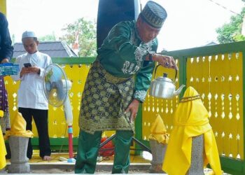 Wakil Bupati Farhan menyiramkan air ke makam Pangeran Iranata. Foto: Prokopim Pemkab Ketapang.