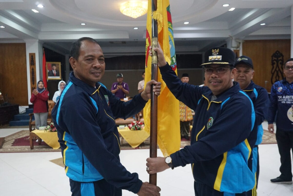 PJ Bupati Mempawah H Ismail menyerahkan bendera Kontingen POPDA Kabupaten Mempawah kepada Kabid Disdikpora Helmi. (Foto, Bayu - Humas dan Prokolol)