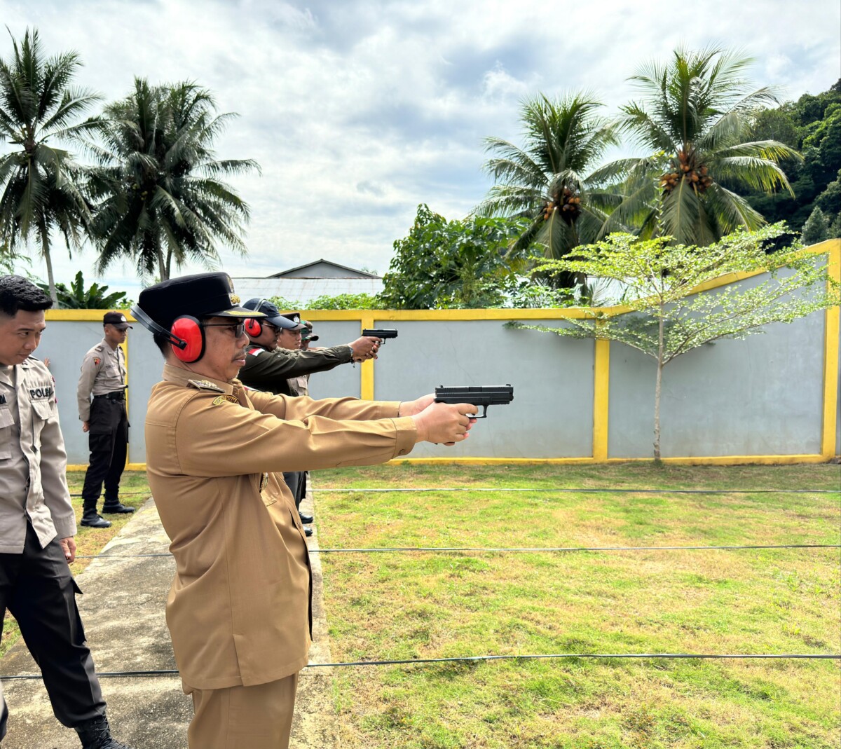 PJ Bupati Mempawah H. Ismail mencoba senjata yang digunakan dalam lomba menembak HUT Bayangkara ke 78