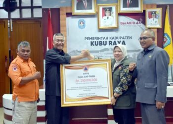 Pj Bupati Kubu Raya saat menerima bantuan dari BNPB