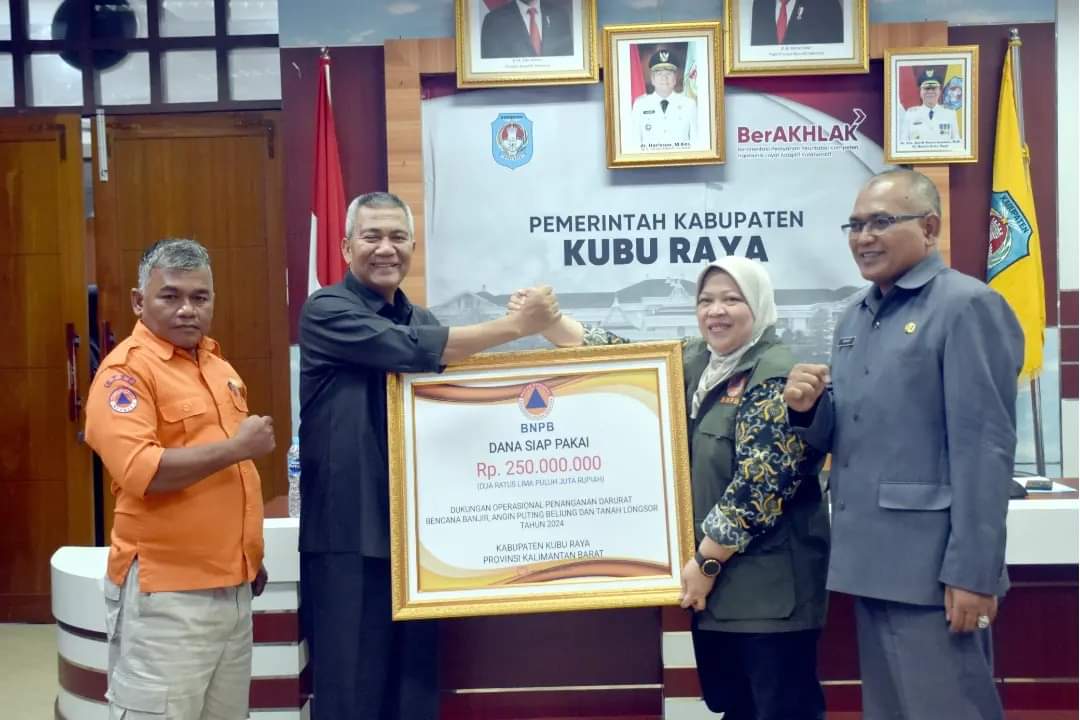 Pj Bupati Kubu Raya saat menerima bantuan dari BNPB