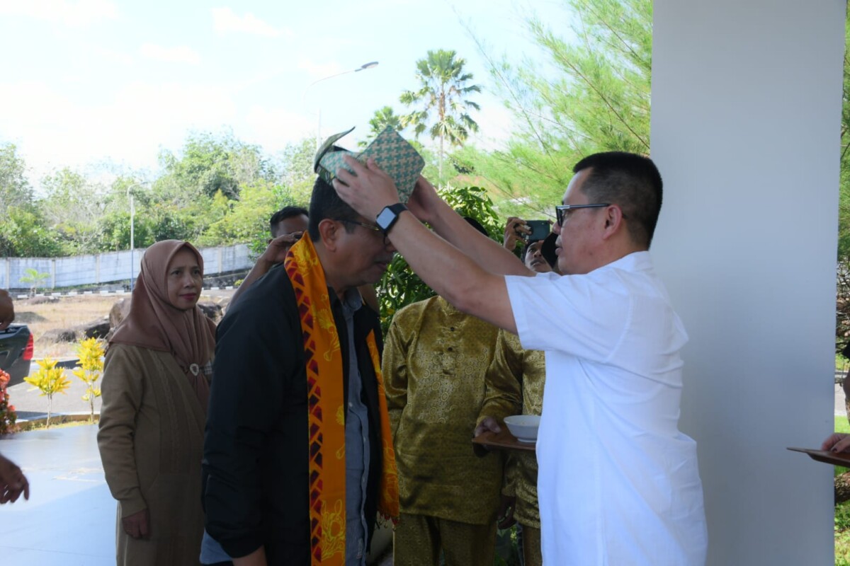 Pejabat Bupati Kayong Utara Alfian saat dipakaikan tanjak oleh sekda Kayong Utara Romi Wijaya saat baru sampai di rumah dinas bupati. Sabtu.(22/6/2024).Foto. Porkopim