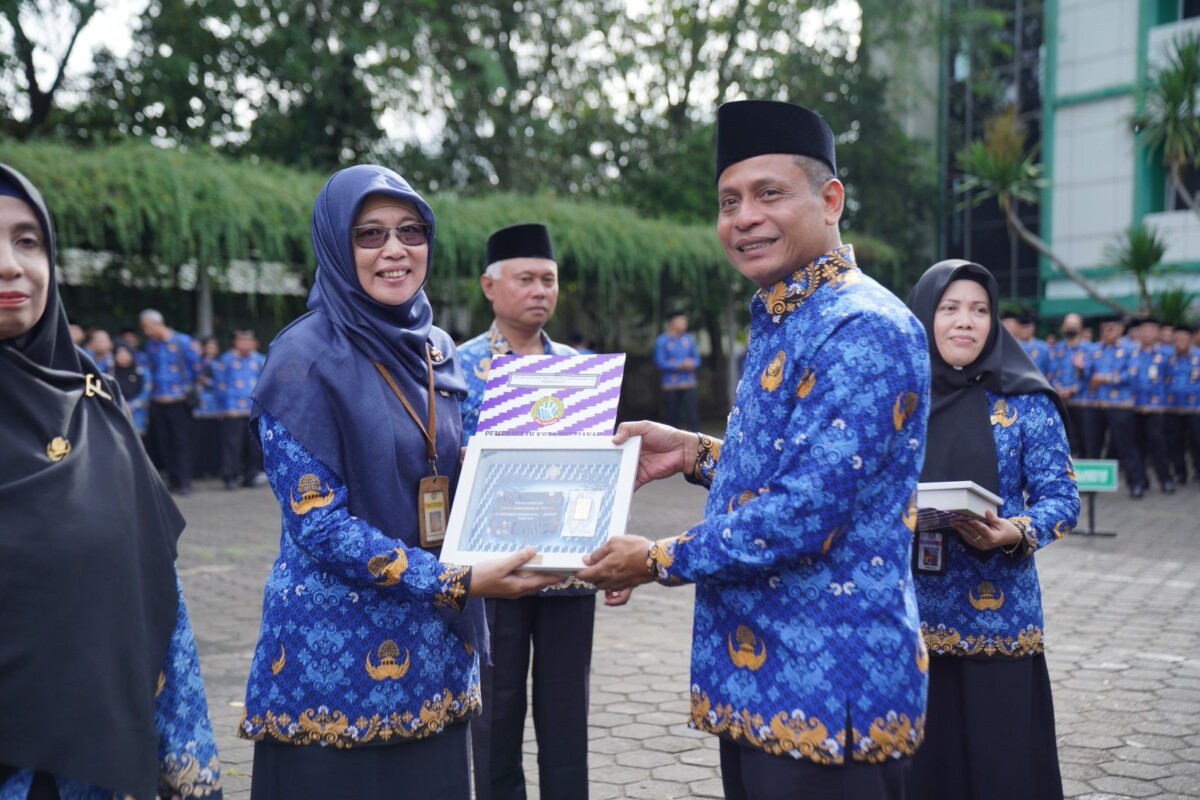 Pj Wali Kota Pontianak Edi Suryanto menyerahkan piagam penghargaan kepada Endang Sayekti sebagai PNS Jabatan Administrator Berprestasi peringkat pertama.