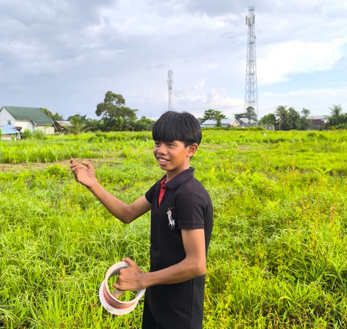 Seorang remaja menggulung tali senar saat dirazia Tim Langit Biru bersama petugas PLN, Kamis (14/11/2024) sore. Foto: Deska Irnan Syafara/Jurnalis.co.id