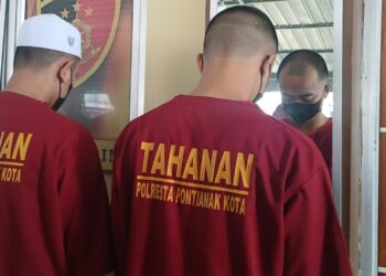 Tersangka DR dan IM mengenakan baju tahanan setelah ditangkap Tim Jatanras Polresta Pontianak lantaran melakukan persetubuhan terhadap anak dibawah umur secara bergiliran. FOTO: Achmad Mundzirin/JURNALIS.co.id