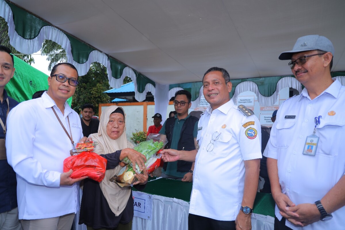 Caption Foto : Pj Wali Kota Pontianak Edi Suryanto menyerahkan secara simbolis paket kebutuhan pokok kepada Tukinem yang berbelanja di Operasi Pasar Murah ,Pontianak Timur. Foto : Diskominfo