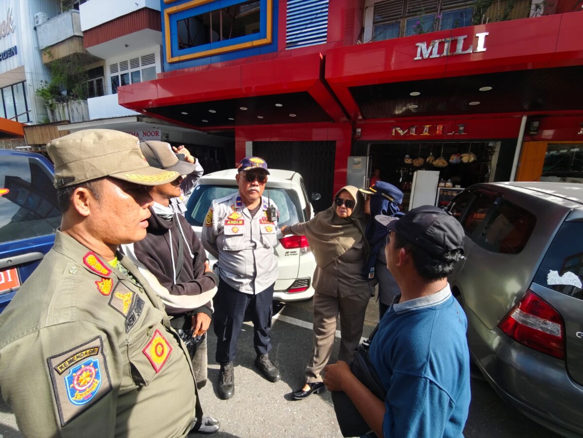 Caption Foto : Petugas mendatangi juru parkir untuk menyampaikan secara persuasif agar melunasi tunggakan retribusi parkir.