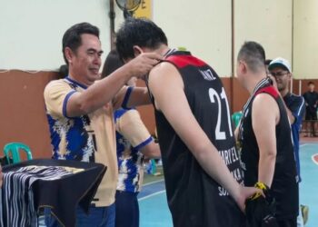 Caption: Asisten Bupati, Heryandi memasangkan trofi juara ke salah satu peserta lomba basket. Foto: Prokopim Pemkab Ketapang.