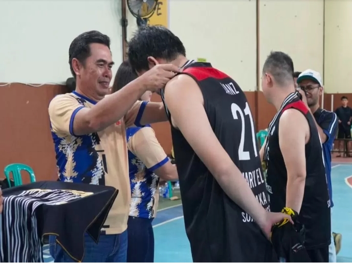 Caption: Asisten Bupati, Heryandi memasangkan trofi juara ke salah satu peserta lomba basket. Foto: Prokopim Pemkab Ketapang.