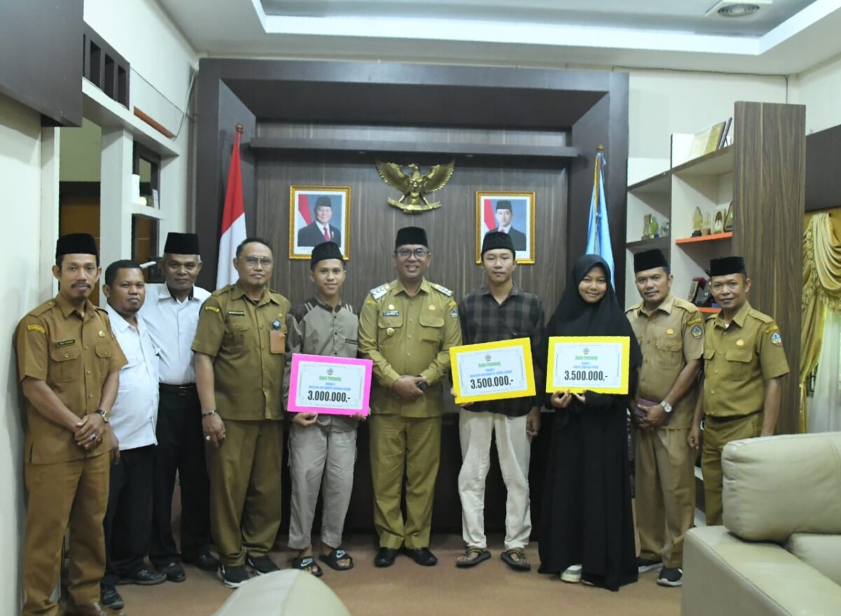 PJ Alfian salam didampingi jajaran Kesra dan pengurus LPTQ saat menyerahkan bonus kepada kafilah yang berhasil juara.di Ruang Kerja Bupati, Sukadana, Senin (30/12/2024) Foto. (Porkopim)