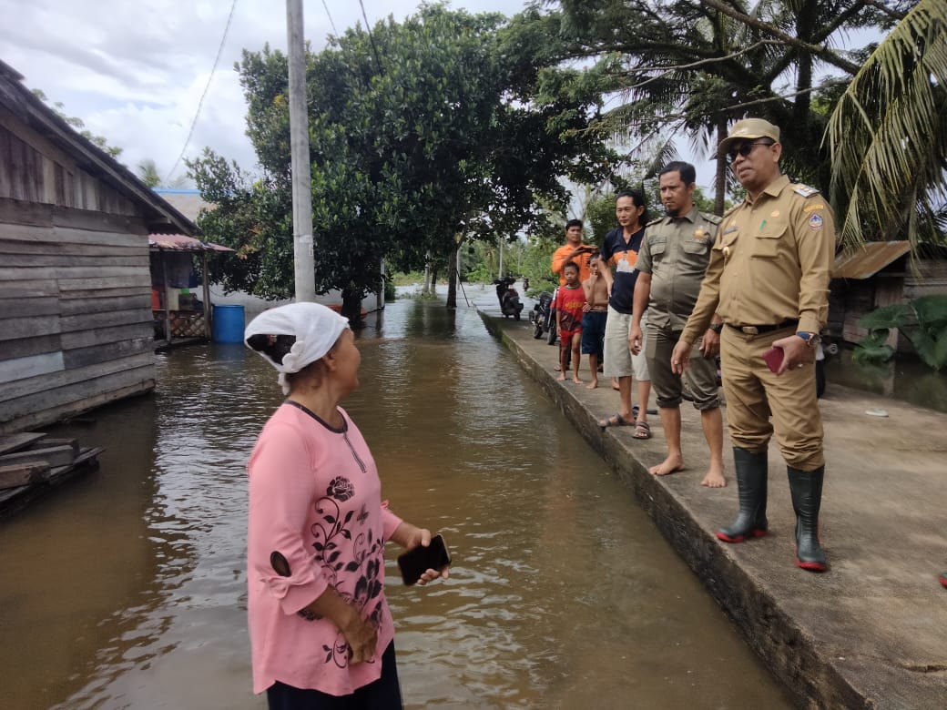 Penjabat PJ Bupati Alfian Salam didampingi BPBD Kayong Utara saat meninjau lokasi banjir di Desa Simpang Tiga dan Riam Berasap. Senin (20/1/2025). Foto (Porkopim)