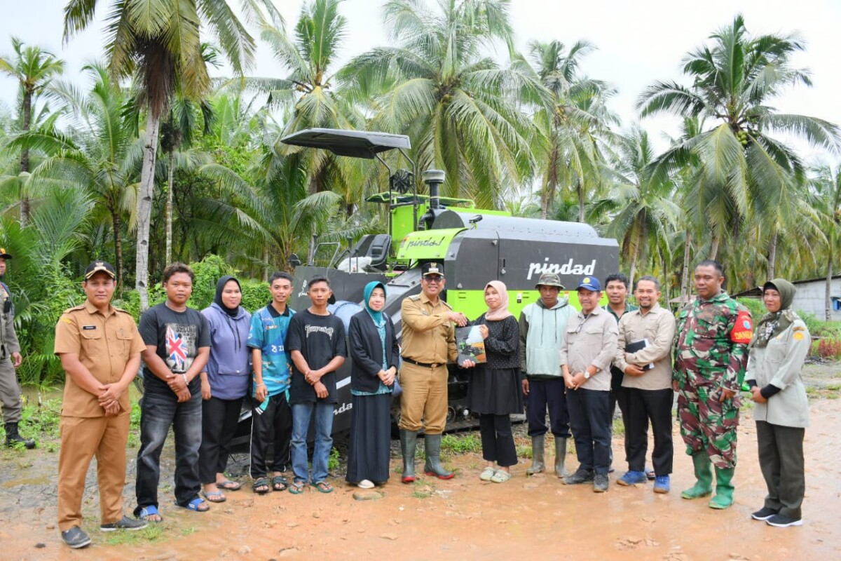 Pejabat PJ bupati Alfian saat menyerahkan bantuan mesin pemanen dari Kementerian Pertanian RI kepada Brigade Pangan Desa Dusun Besar, Kecamatan Pulau Maya, Selasa (21/1/2025). Foto (Porkopim)