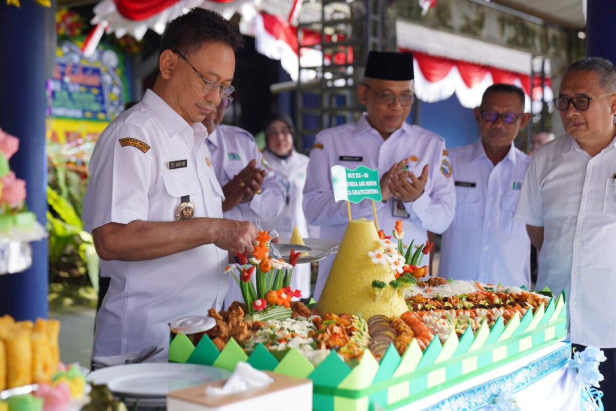 Wali Kota Pontianak Edi Rusdi Kamtono memotong tumpeng saat menghadiri syukuran ulang tahun ke-50 PDAM Tirta Khatulistiwa.