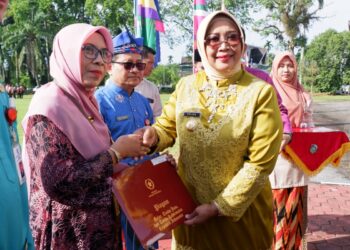 Bupati Mempawah, Erlina, saat menyerahan tanda kehormatan Satya Lencana Karya Satya kepada aparatur sipil negara. (Foto, Humas Komindo Pemkab Mempawah)