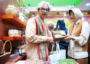 Ketua Dekranasda Pontianak Yanieta Arbiastutie menjelaskan produk tas rajut kepada Desainer Didiet Maulana.