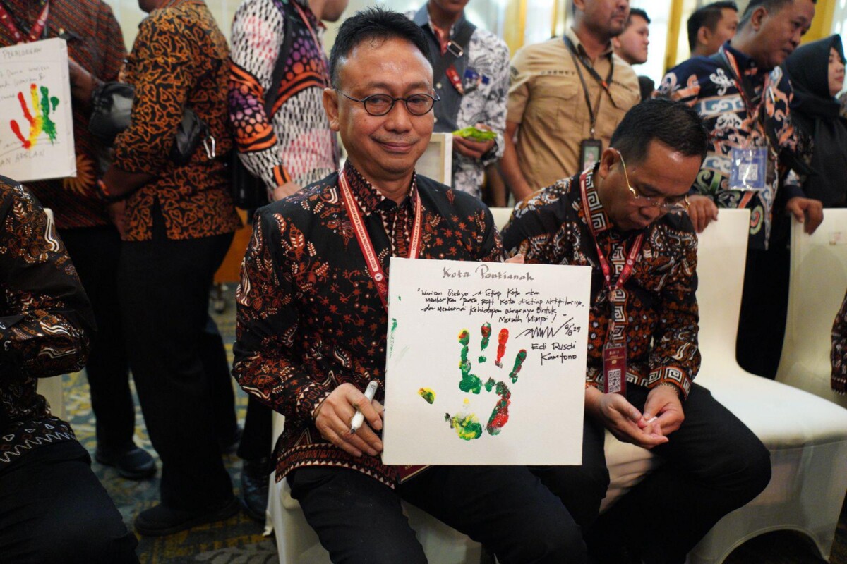 Wali Kota Pontianak Edi Rusdi Kamtono memperlihatkan pesan yang ditulis di atas kertas lukisan telapak tangannya pada Rakernas Jaringan Kota Pusaka Indonesia (JKPI) 2025.