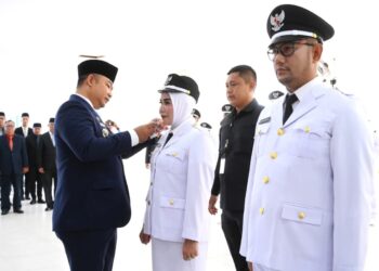 Bupati Ketapang, Alexander Wilyo menyematkan tanda pangkat kepada salah satu kepala desa terpilih saat prosesi pelantikan, Jumat (8/8/2025).(Foto: Prokopim Pemkab Ketapang).