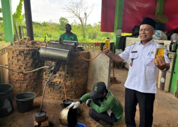 Kepala Dinas Lingkungan Hidup Kota Pontianak Syarif Usmulyono memperlihatkan minyak bakar hasil olahan dari sampah plastik yang digunakan sebagai bahan bakar untuk kendaraan operasional angkutan sampah.