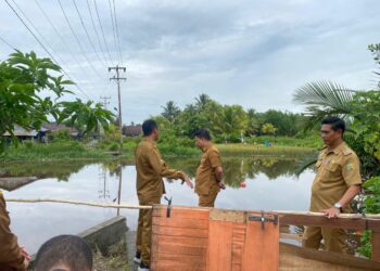 Bupati Sambas H. Satono, S.Sos.I., M.H. bersama Kepala Dinas Pekerjaan Umum dan Penataan Ruang (PUPR) Kabupaten Sambas Drs. Hermanto, M.Si. dan Camat Tebas Dedy Zulkarnain, S.Sos. meninjau langsung kondisi jembatan yang putus di Dusun Kenanga 2, Desa Tebas Sungai, Kecamatan Tebas, Senin (15/9/2025).