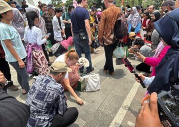 Para wisatawan asal Jerman tengah mencoba mendirikan telur di kawasan Tugu Khatulistiwa saat Kulminasi Matahari.