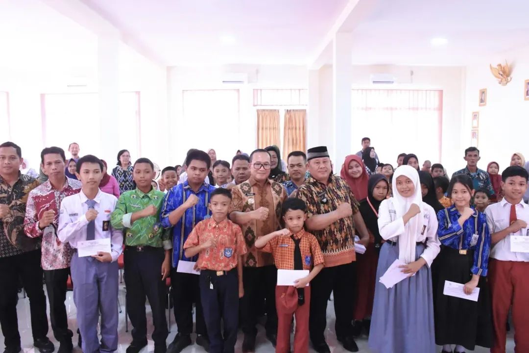 Bupati Kubu Raya Sujiwo serahkan bantuan untuk 60 pelajar berprestasi di Aula Kantor Desa Limbung, Kamis (9/10/2025).