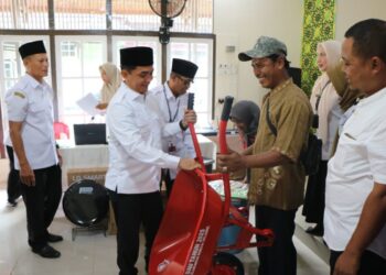 Wakil Wali Kota Pontianak Bahasan menyerahkan bantuan barang secara simbolis yang bersumber dari DAU dan PAD kepada masyarakat.