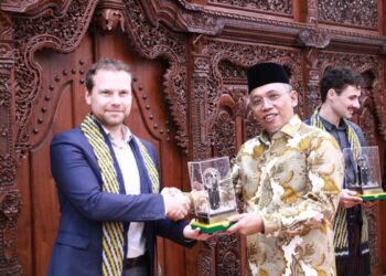 Sekretaris Daerah Kota Pontianak Amirullah menyerahkan cenderamata Tugu Khatulistiwa kepada Deputy Head International Department ACQUIN, Robert Raback.
