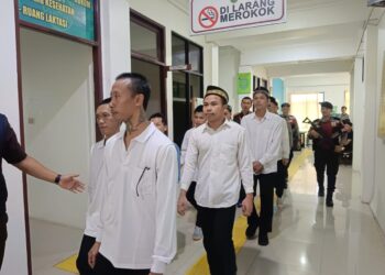 Dikawal Polisi, Delapan terdakwa kasus penyelundupan narkotika saat akan memasuki ruangan persidangan PN Putussibau. Taufik