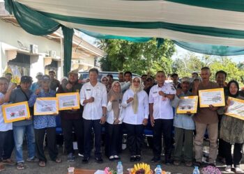 Erlina, didampingi Kepala Dinas PKPP, saat menyerahkan bantuan alsintan kepada kelompok tani di Kabupaten Mempawah. (Foto Prokopim Mempawah)