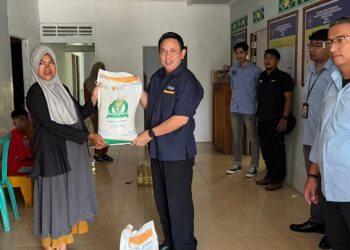 Kepala Perum Bulog Kantor Cabang Ketapang, Jarak Matu menyerahkan bantuan secara simbolis ke salah satu masyarakat Sungai Jawi, Selasa (16/12). Foto: JURNALIS.co.id