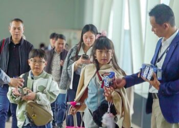 General Manager Novotel Pontianak Convention Centre Rispugi Listanto membagikan kukis ke penumpang Garuda Indonesia di bandara Supadio Pontianak, Kab. Kubu Raya, Kamis 18 Desember 2025.