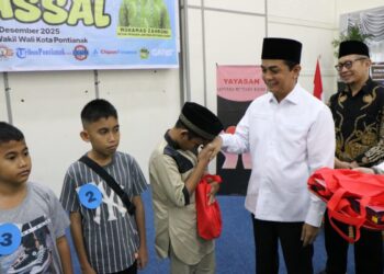 Wakil Wali Kota Pontianak Bahasan menyerahkan paket kepada peserta khitanan massal.