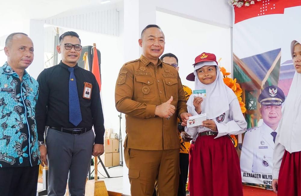 Bupati Ketapang, Alexander Wilyo menyerahkan langsung Kartu Ketapang Pintar kepada salahh satu siswa penerima, Senin (22/12). Foto: Prokopim.