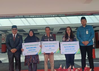 Sekretaris Daerah Kapuas Hulu Ambrosius Sadau saat menyerahkan santunan JKM kepada ahli waris peserta BPJS Ketenagakerjaan. Ist