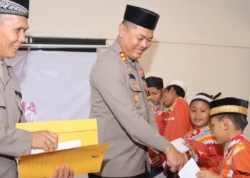 Kapolres Mempawah saat menyerahkan Tali asih kepada sejumlah Santri pada kegitan Buka puasa bersama Personel Polres, anggota Bayangkari Mempawah di ruang Rupatama Polres Mempawah