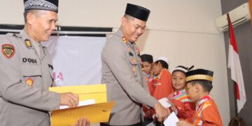 Kapolres Mempawah saat menyerahkan Tali asih kepada sejumlah Santri pada kegitan Buka puasa bersama Personel Polres, anggota Bayangkari Mempawah di ruang Rupatama Polres Mempawah