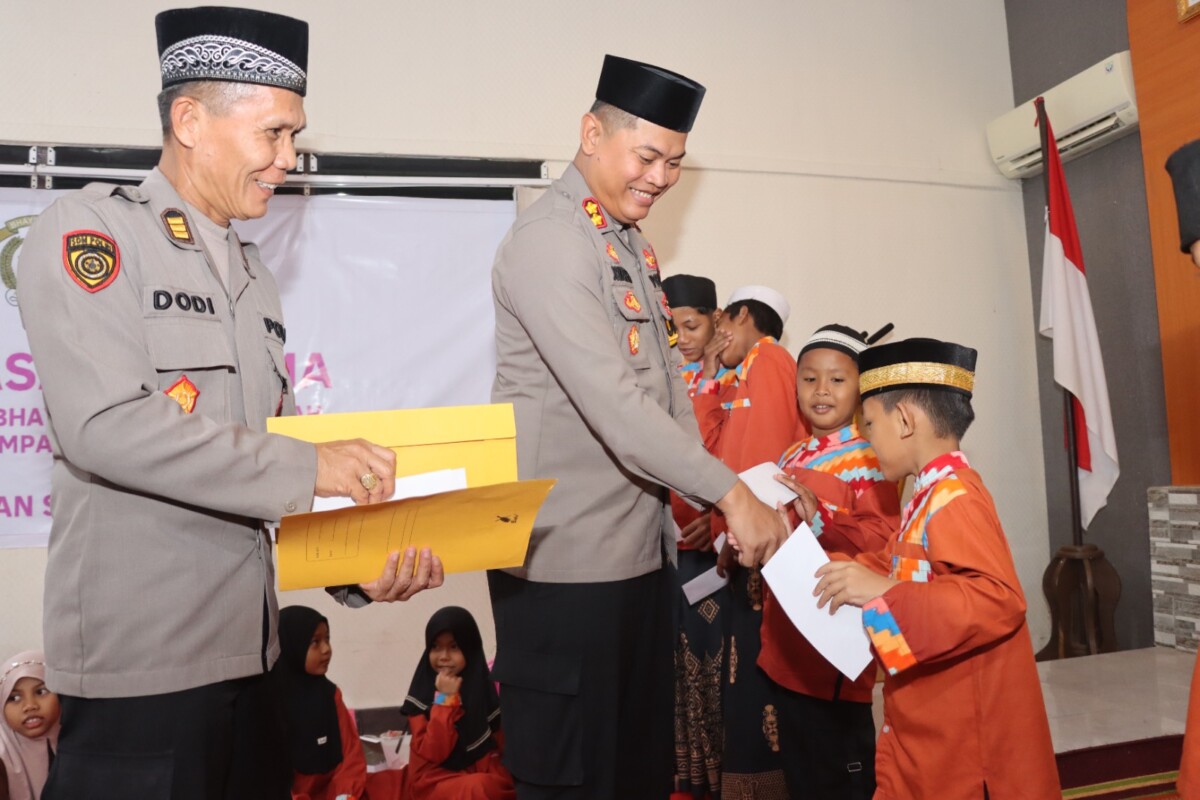Kapolres Mempawah saat menyerahkan Tali asih kepada sejumlah Santri pada kegitan Buka puasa bersama Personel Polres, anggota Bayangkari Mempawah di ruang Rupatama Polres Mempawah