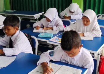 Siswa-siswi tengah mengikuti pembelajaran di ruang kelas.