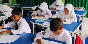 Siswa-siswi tengah mengikuti pembelajaran di ruang kelas.