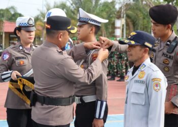 Waka Polres Melawi saat menyematlan pita dalam Apel Gelar Pasukan Operasi Keselamatan Kapuas 2026, Senin (2/2/2026), di halaman Mapolres Melawi
