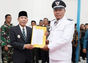 Wabup Jamhuri menyerahkan BA pelantikan Kades Tempurukan hasil Pemilihan PAW. Foto: Prokopim.