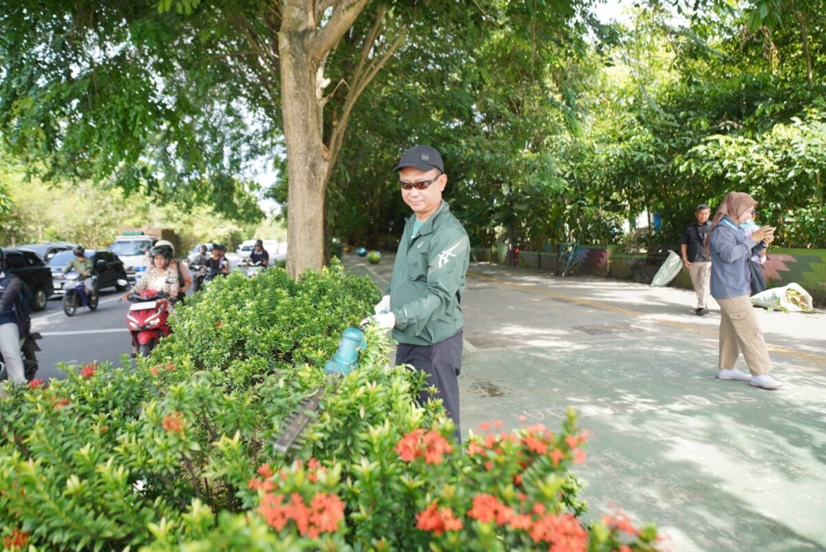 Wali Kota Pontianak Edi Rusdi Kamtono merapikan tanaman hias di trotoar.
