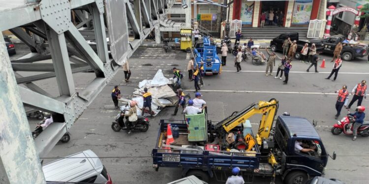 Penertiban poster tidak berijin yang menempel jembatan layang di Jalan Gajah Mada Jember oleh Satgas Infrastruktur dan Tata Ruang (foto: Jurnalis.co.id/Sigit)