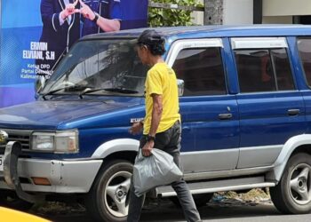Salah satu penerima manfaat dari program AJK Berbagi sedang membawa bantuan sembako yang diberikan AJK, Selasa (10/02). Foto: Jurnalis.co.id