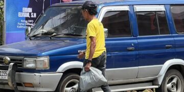 Salah satu penerima manfaat dari program AJK Berbagi sedang membawa bantuan sembako yang diberikan AJK, Selasa (10/02). Foto: Jurnalis.co.id