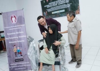 Ketua Bidang Pengabdian Masyarakat PAPDI Kabar, Juhendro saat memenrikan alat bantu ke salah satu penyandang disabilitas. Foto: Istimewa.